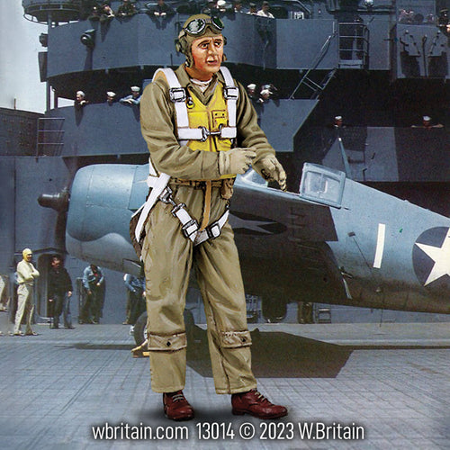A 1/30 scale toy soldier figurine of a U.S. Navy Pilot from 1941-45, dressed in full flight gear including a flight suit, life vest, and helmet with goggles. The pilot stands in front of a WWII-era aircraft on the deck of an aircraft carrier, with crew members visible in the background, highlighting the busy and strategic environment of naval aviation during the war.
