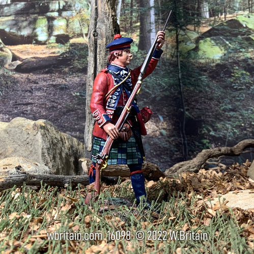 Collectible toy soldier miniature 42nd Royal Highland Regiment. He is loading musket. He is on the battlefield.