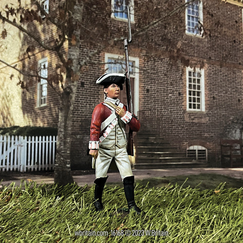 Collectible toy soldier army man 43rd Regiment of Foot Battalion. He is in front of a brick building.