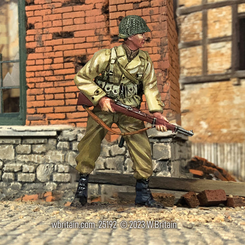Toy soldier army man U.S. Armored Infantryman with M1 Garand, Alert. He is in a town.