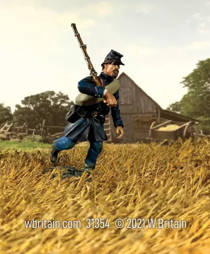 The Federal Infantry in Frock Coat Advancing at Right Shoulder rushes through a golden wheat field, rifle poised. An aged wooden barn stands among the trees under a clear sky.