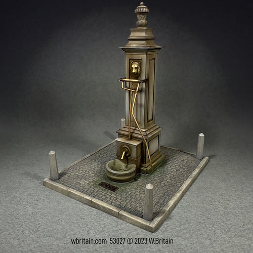 Collectible toy soldier miniature Village Pump It stands on a concrete base surrounded by a gravel path, capturing the historical importance and communal role of such structures in village settings.