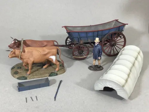 Model of a cart with two cows and a person, accompanied by tools and materials on a gray background.