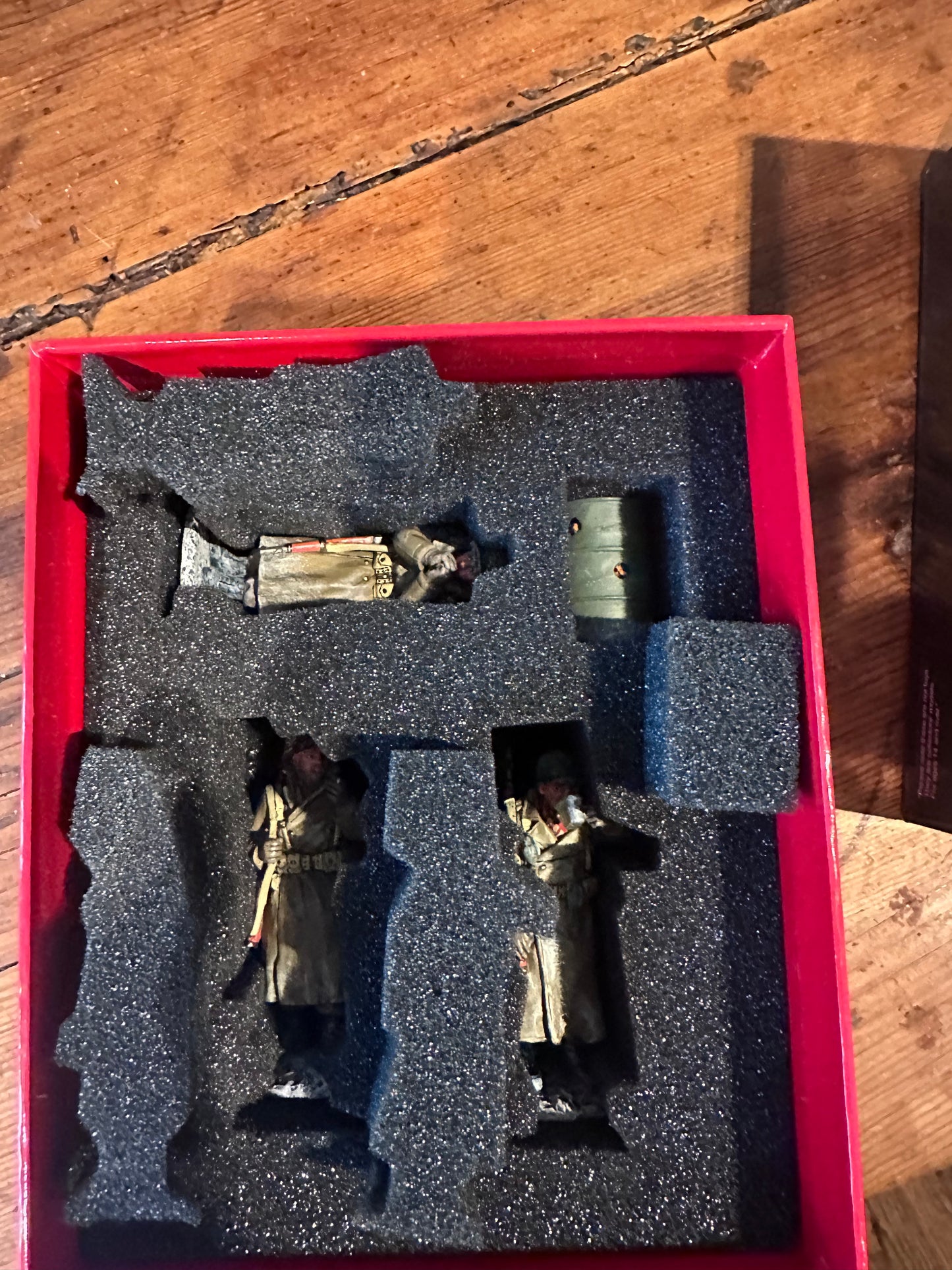 toy soldier Figurines in a red box with black foam padding on a wooden surface