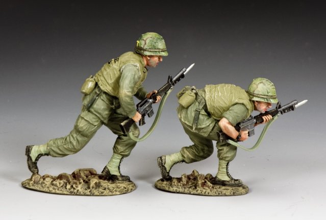 Moving Forward. Two toy soldiers in military gear with rifles on a gray background