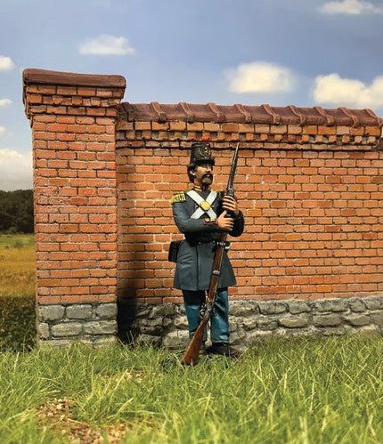 Military miniature U.S. Marine Dress Uniform 1859 standing before a brick wall.