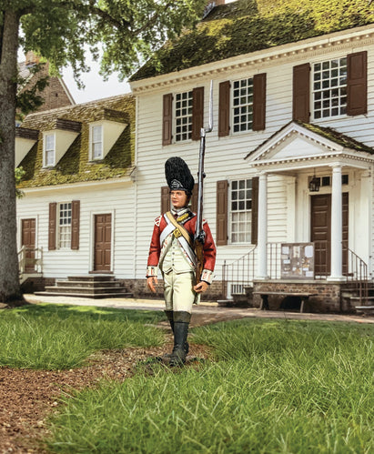 Collectible toy soldier miniature 43rd regiment of foot Grenadier marching in front of colonial home.