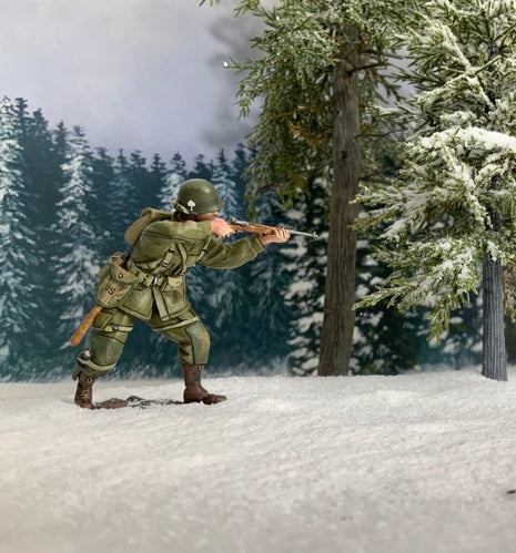 Collectible toy soldier miniature U.S. 101st Airborne Standing Firing Carbine. He is in the woods and snow.