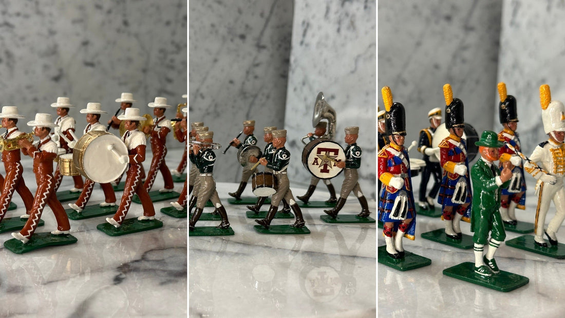 Three hand-painted gloss toy soldier marching bands side by side: the University of Texas Longhorn Band in burnt orange and white hats, the Fightin' Texas Aggie Band with an A&M bass drum, and the Notre Dame band with the Leprechaun and kilted Irish Guard