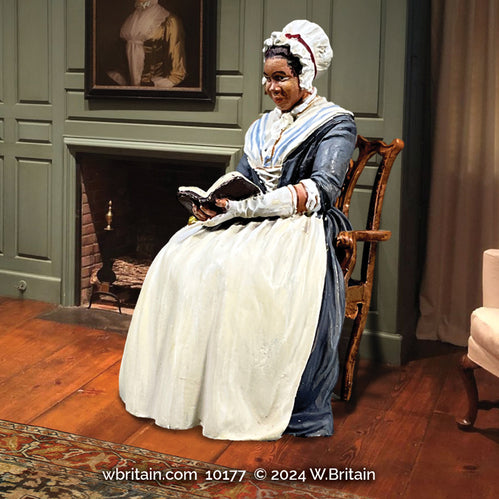 Civilian miniature Phillis Wheatley figurine. She is sitting in a chair reading a book.