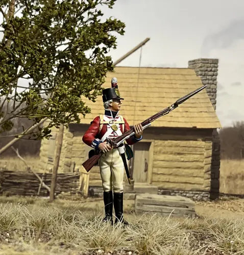 Toy Soldier miniature army men Veteran figurine standing in front of a cabin.