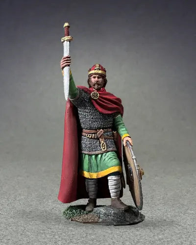 A detailed military miniature of a medieval knight in armor holds a sword upright and a round shield. The knight, with a red cape, crown-like helmet, and beard, stands on a textured base.