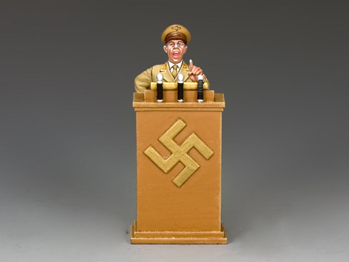 Model of a figure in military uniform behind a podium with a swastika symbol on a gray background