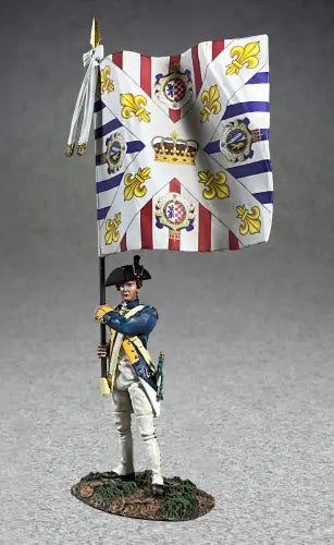  A collectible toy soldier figurine of a historical soldier in a blue uniform holding a large flag with white and purple stripes, yellow fleurs-de-lis, and ornate circular designs. The soldier stands on a grassy base.