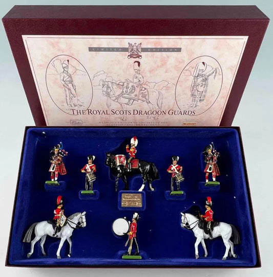 A boxed set of Royal Scots Dragoon Guards figurines. The set includes six soldiers, two on horseback, in traditional uniforms with red jackets and black hats. The box features illustrations and the title The Royal Scots Dragoon Guards.