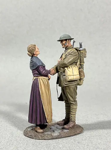 A figurine of a woman in a long dress shaking hands with a toy soldier in World War I-era uniform, helmet, and backpack, set against a plain gray background.