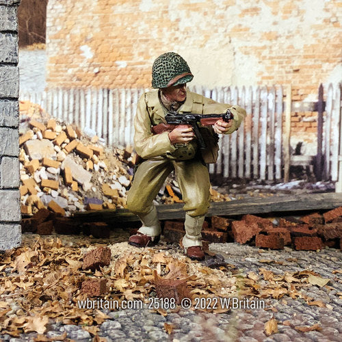Collectible toy soldier army man U.S. Infantry NCO Crouching with Thompson. He is in a town.