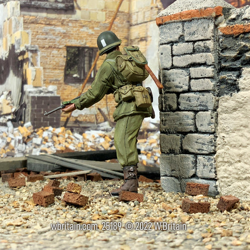 Collectible toy soldier army man U.S. Infantry Company Officer Looking Around Corner next to a wall.