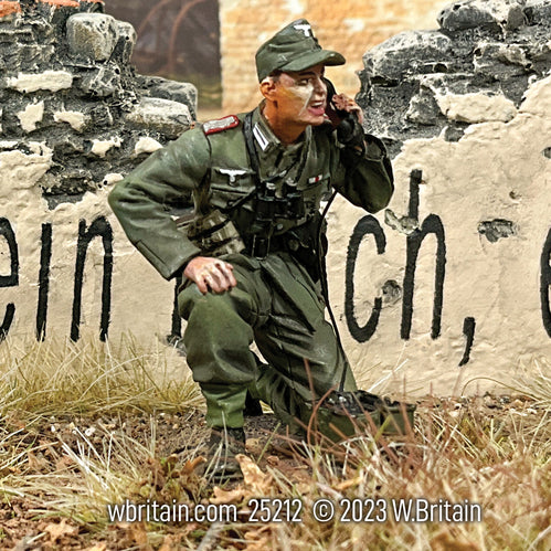 Collectible toy soldier miniature army men German Artillery Officer on Field Phone. He is near a wall.
