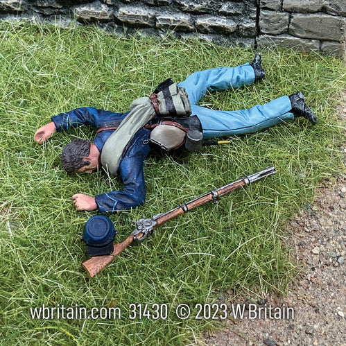 Toy soldier army men miniature Union Infantry Casualty in State Jacket. Laying in the grass.