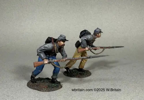 Rebel Steel. Two miniature soldiers in Civil War-era uniforms crouch and advance with rifles and bayonets. They wear gray jackets, caps, backpacks, and stand on textured bases.