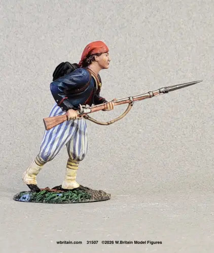W. Britain Louisiana Tiger advancing at the run with bayonet — Confederate Zouave in red fez, blue jacket, striped trousers. 1/30 scale matte-painted, 1861-62. Catalog 31507.