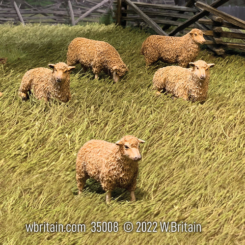 Collectible civilian miniature figurines flock of sheep. In high grass field.