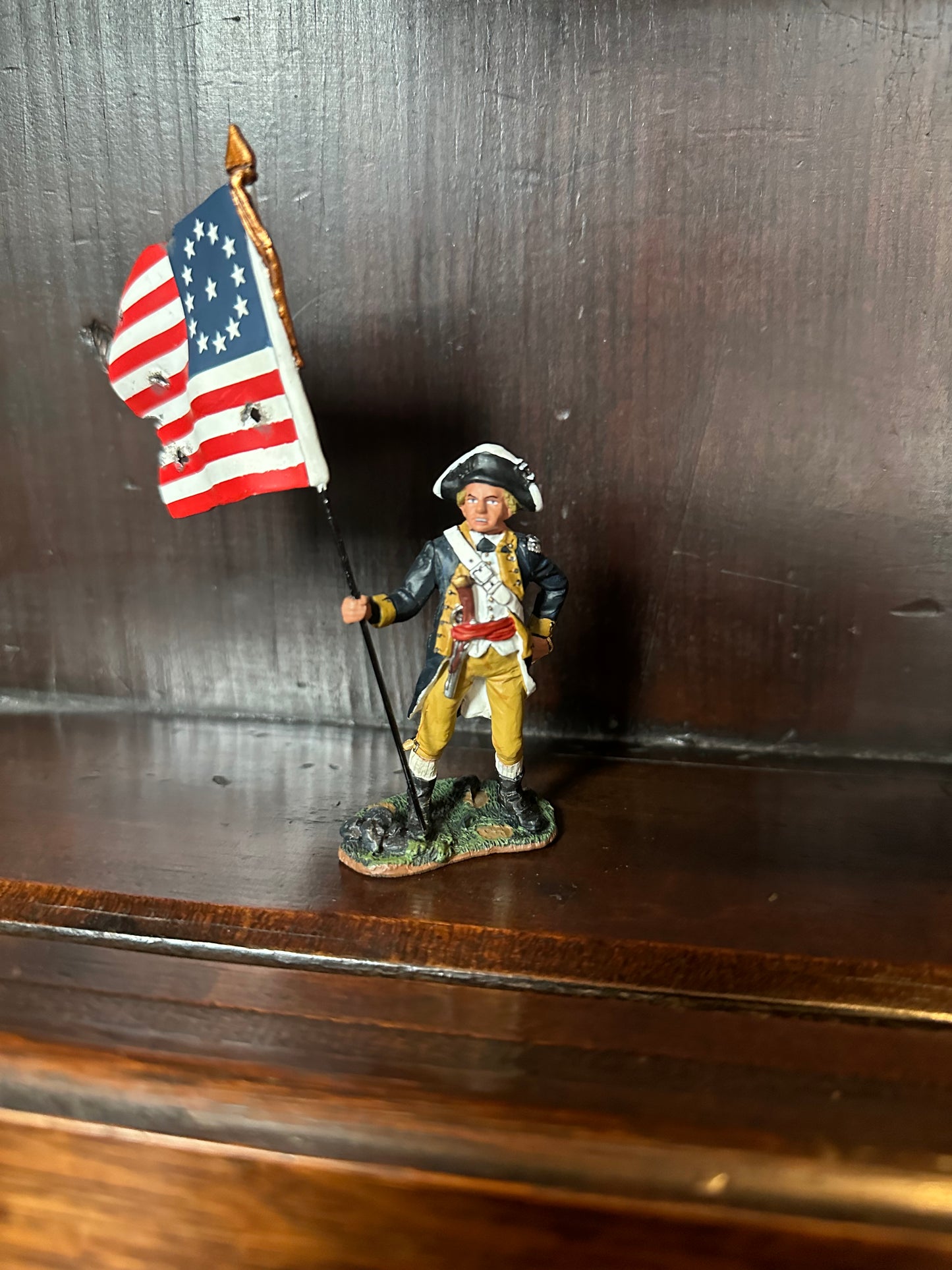 Collectible toy soldier miniature army men Standing Flagbearer. Displayed on a shelf.