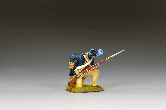 A miniature figurine of a soldier in colonial-era uniform kneels on one knee, holding a rifle with a bayonet. The soldier wears a blue coat, beige pants, and a blue cap, set against a neutral background.