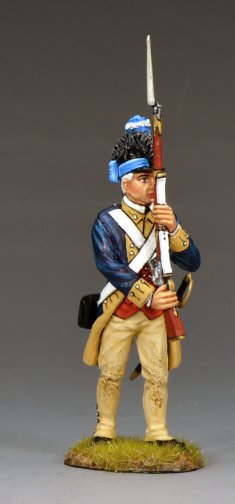 A painted miniature figurine of a Revolutionary War soldier in blue and tan uniform holding a musket upright, standing on a small patch of grass against a plain gray background.