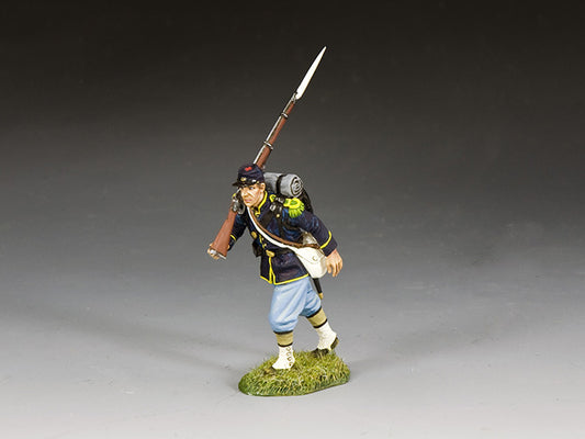 Union infantryman marches with rifle slung on shoulder, wearing full gear and dark blue frock coat with sky blue trousers.