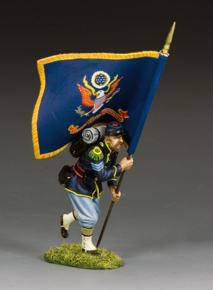 The King and Country Sergeant with Regimental Flag depicts a toy soldier in a blue Civil War uniform, running with a large flag featuring an eagle emblem, complete with backpack and cap, on a grassy base.