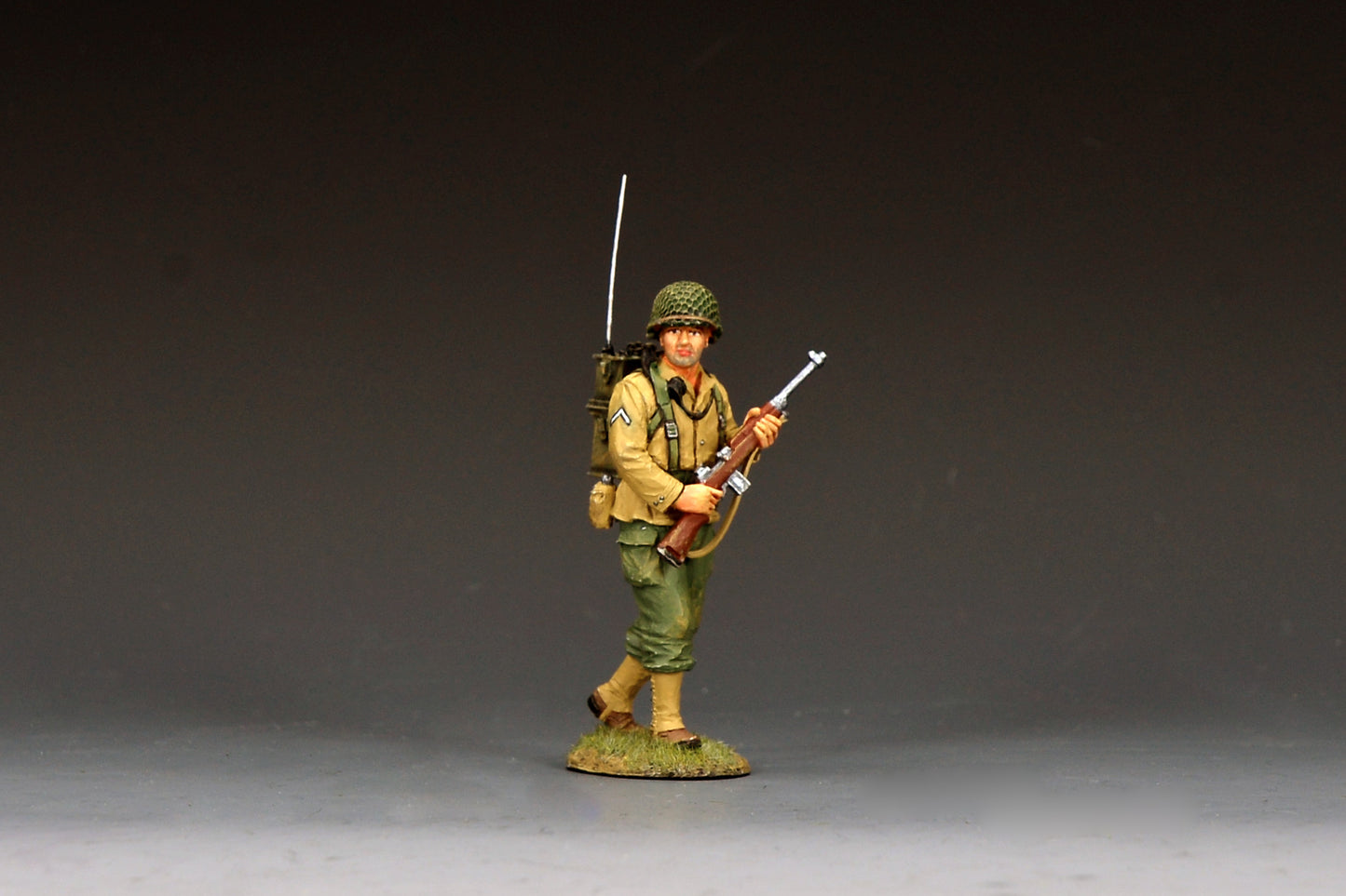 King & Country DD401 figure of a U.S. Army radioman walking with an SCR-300 backpack radio and tall whip antenna, an M1 Carbine in hand, PFC stripe on his sleeve.