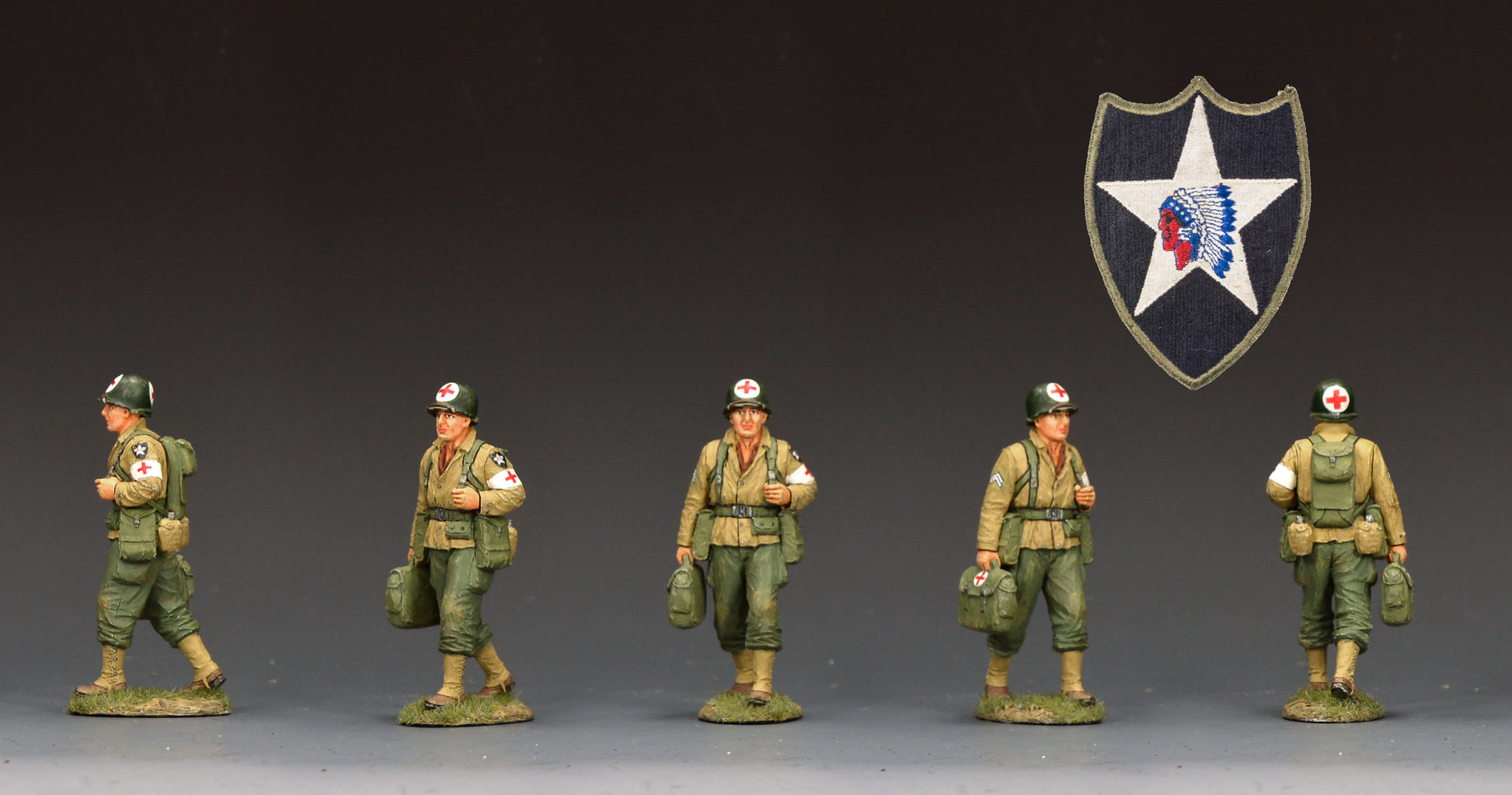 DD405 painted military figurines in olive green uniforms standing on a dark studio background, with a shield-shaped insignia featuring a white star and red/blue emblem above them.