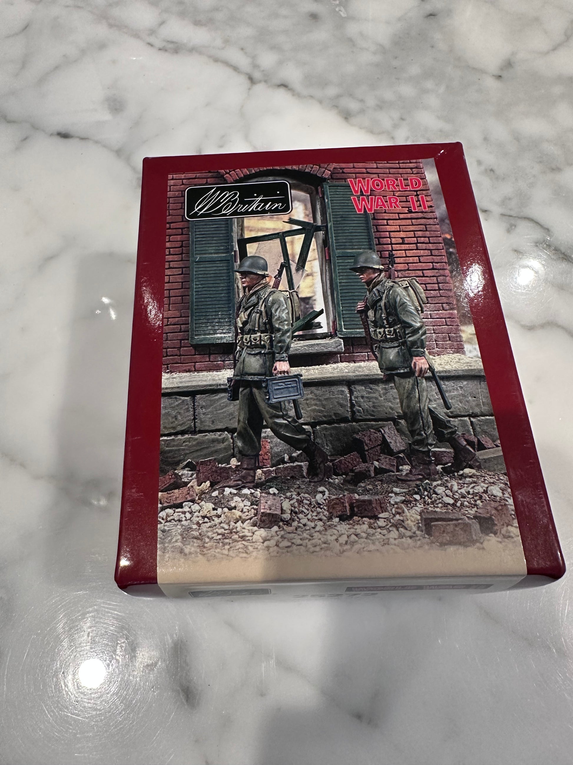Packaging for toy soldiers with a military-themed cover on a marble surface