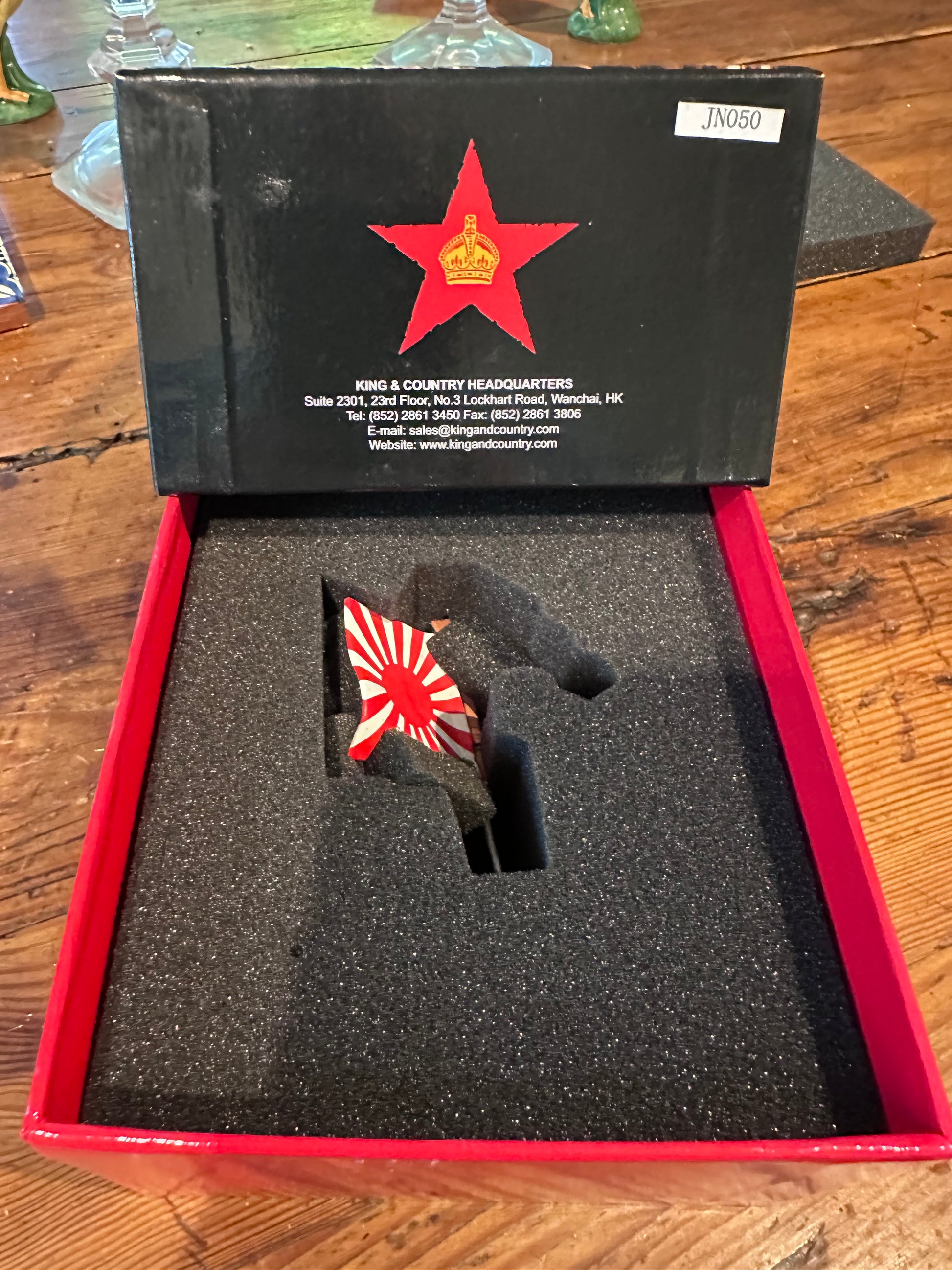 Open toy soldier box with a red star emblem on a wooden surface