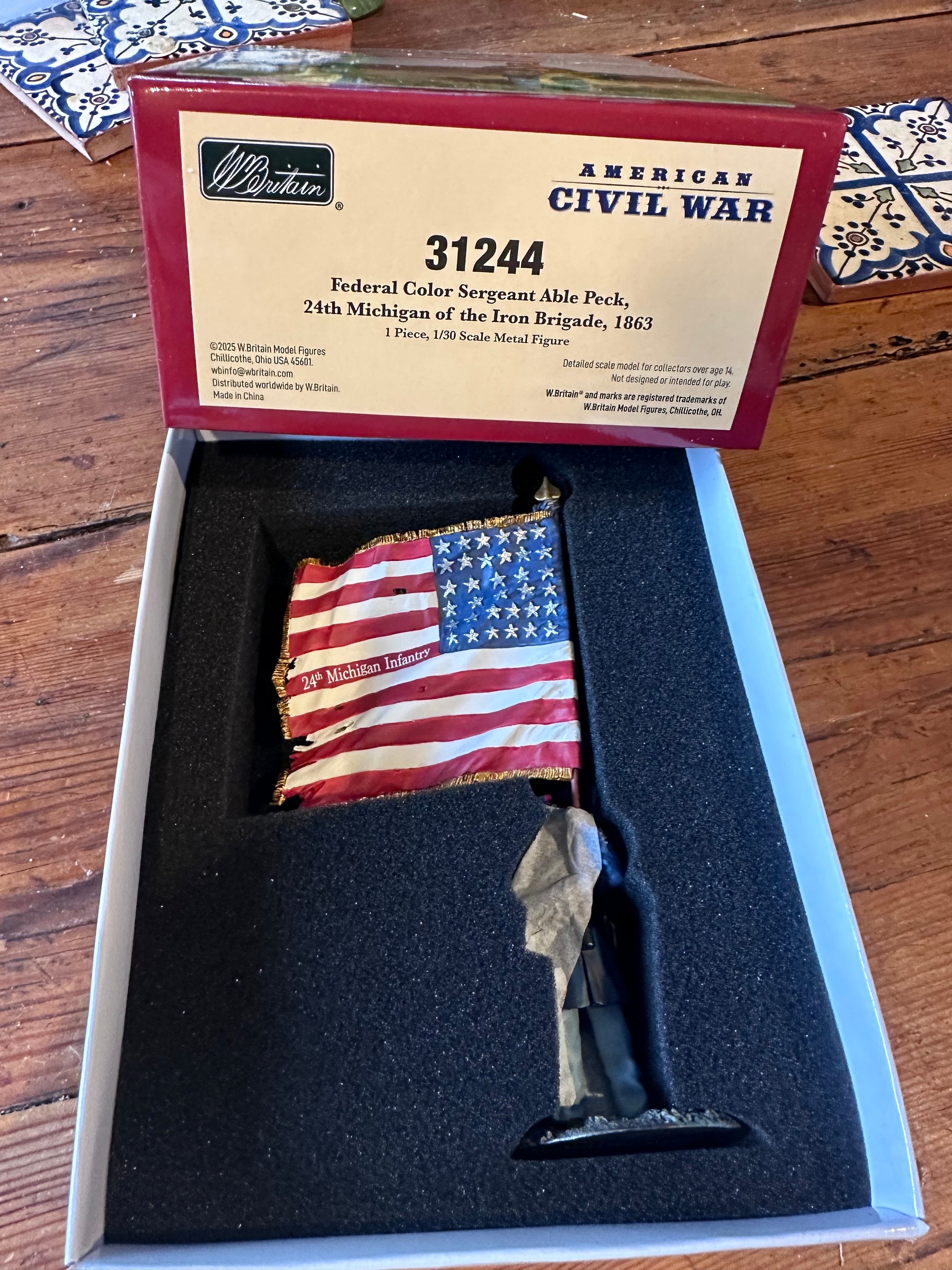 American Civil War flag in a display case with a certificate of authenticity on a wooden surface.