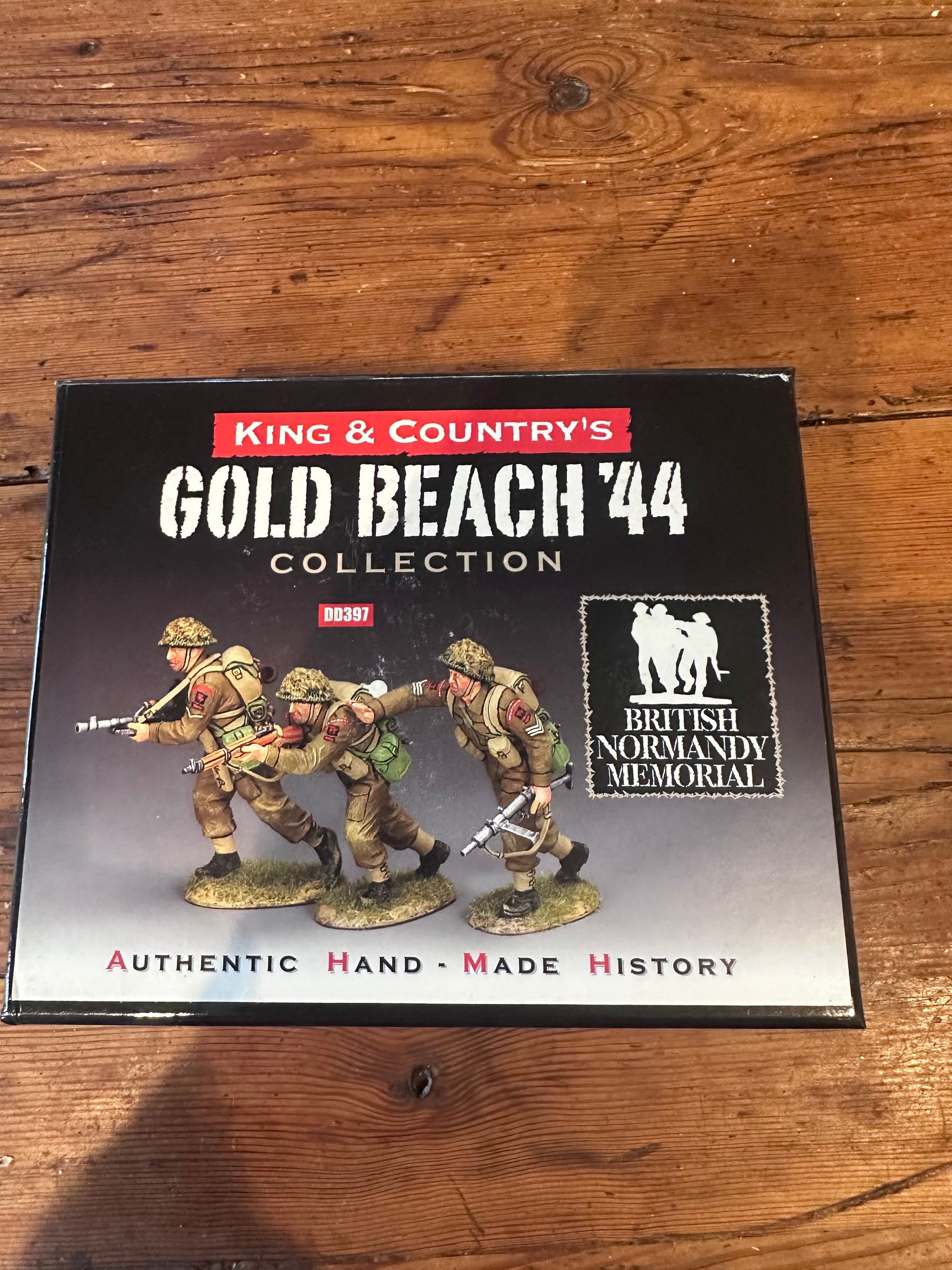 King & Country's Gold Beach '44 Collection box set on a wooden tabletop, featuring painted World War II infantry figures on the front cover.