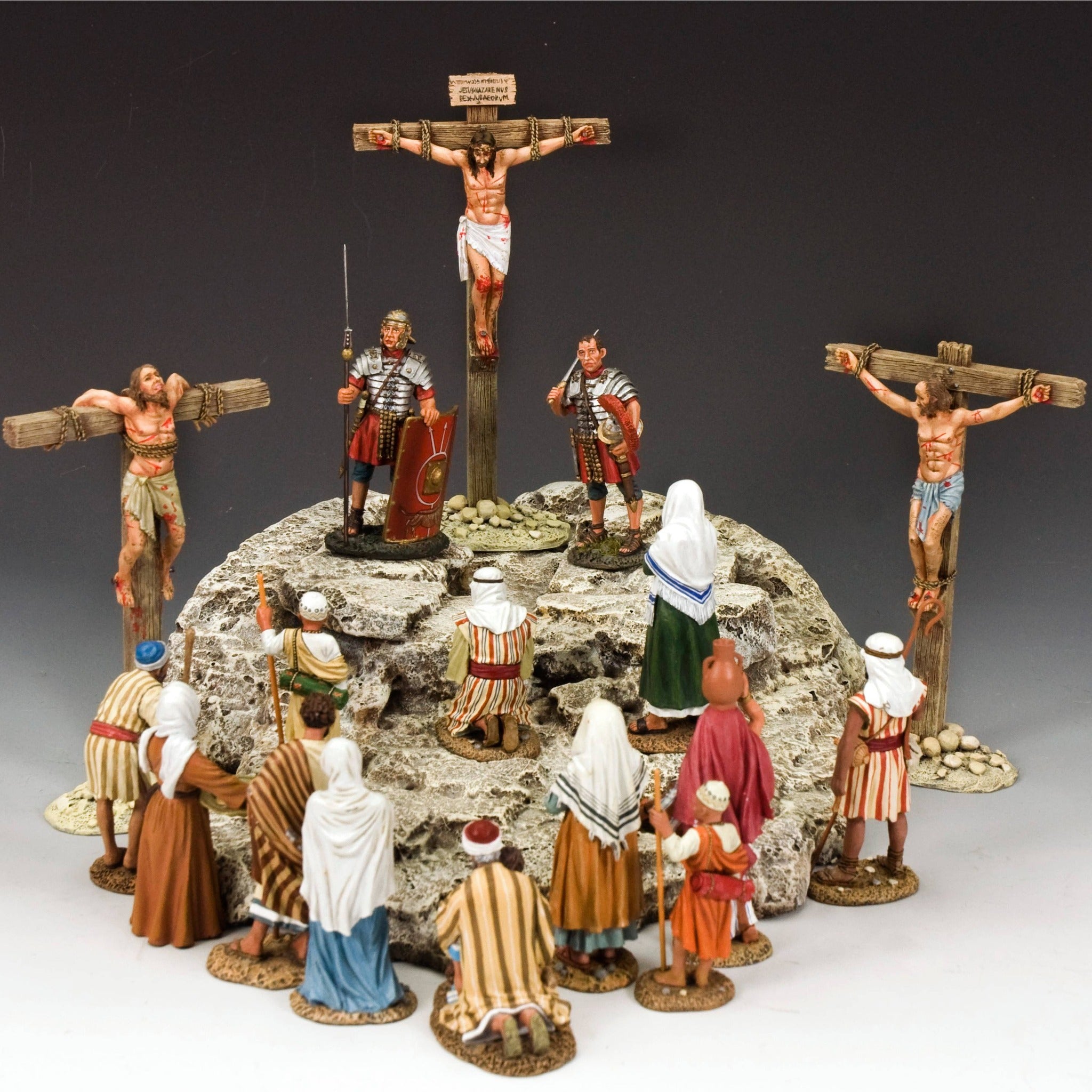 Model of the crucifixion scene with figures around a central cross on a gray background