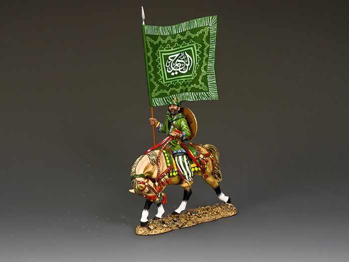 Saracen standard bearer on horseback carrying a large green flag with ornate Koranic script and Islamic geometric decoration.