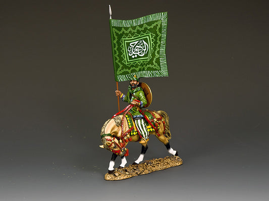 Saracen standard bearer on horseback carrying a large green flag with ornate Koranic script and Islamic geometric decoration.