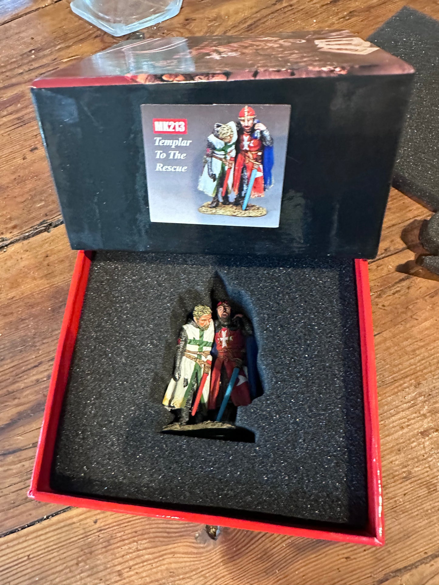Toy figure The Templar & The Lazarene in a red box on a wooden surface