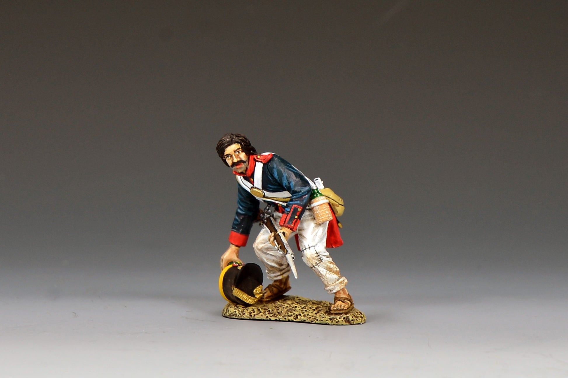 King & Country S.A.A. Soldier Reaching For His Shako, Mexican line infantryman bending to pick up his fallen shako, blue coatee with red facings, Alamo 1836, 1/30 60mm matte figure, RTA132