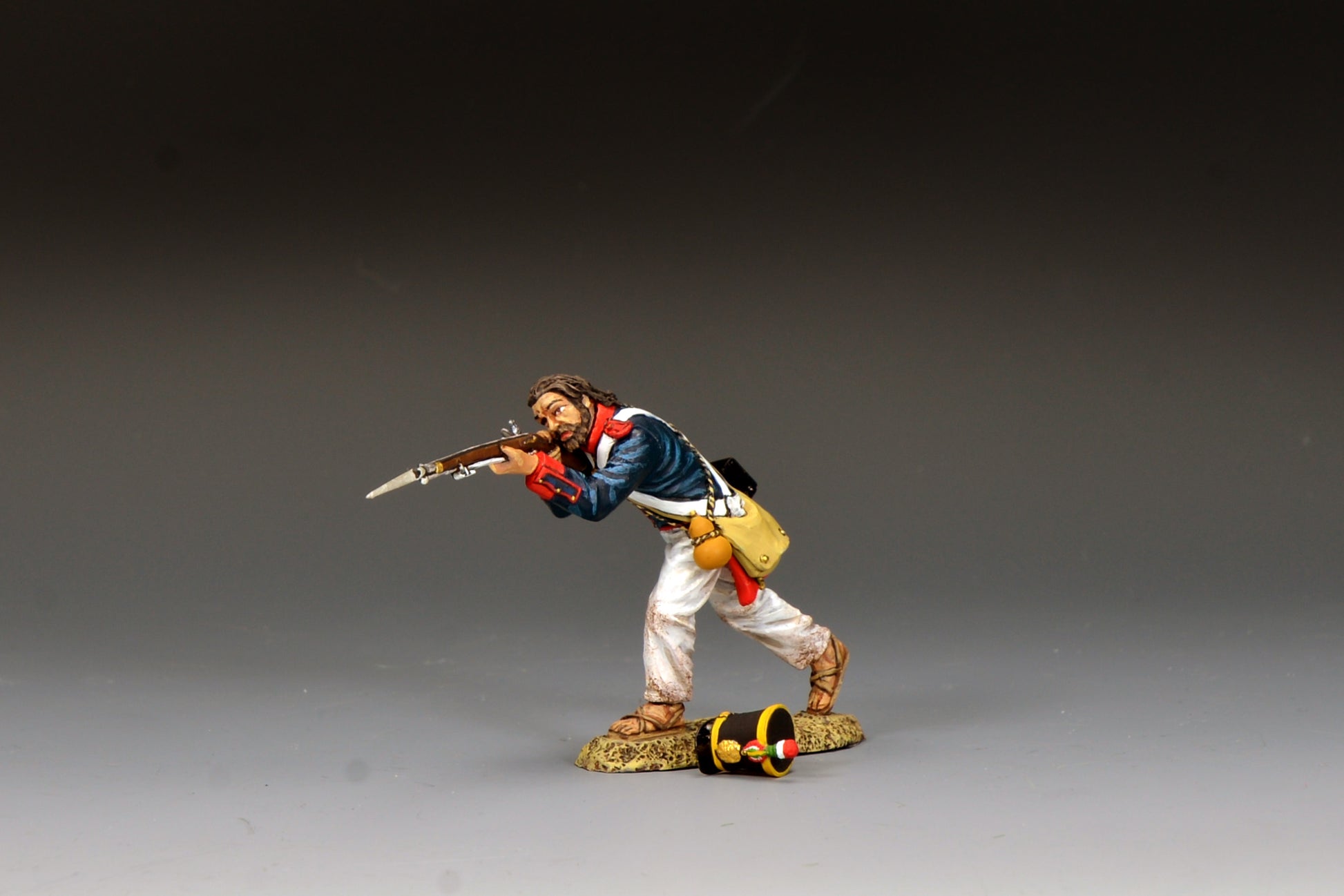 King & Country S.A.A. Soldier Advancing Firing, Mexican line infantryman firing bayoneted musket with shot-off shako on ground at his feet, blue coatee with red facings, Alamo 1836, 1/30 60mm matte figure, RTA142