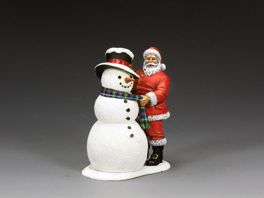Santa Claus figurine standing next to a smiling snowman with a tartan scarf and snow-dusted top hat.