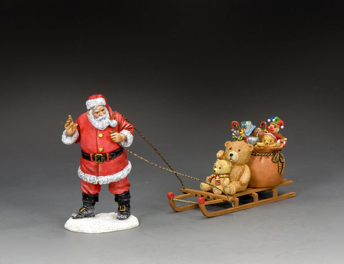Santa Claus figurine pulling a toy-filled sled with teddy bears and a sack of gifts, hand-painted in matte finish.