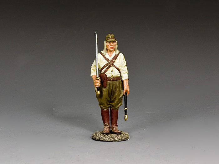 Japanese WWII sergeant stands holding unsheathed sword and scabbard, wearing tropical uniform, cap, and brown leather boots.