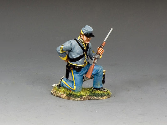 Toy soldier of a kneeling Confederate corporal loading a carbine, wearing gray jacket and blue trousers with yellow trim.