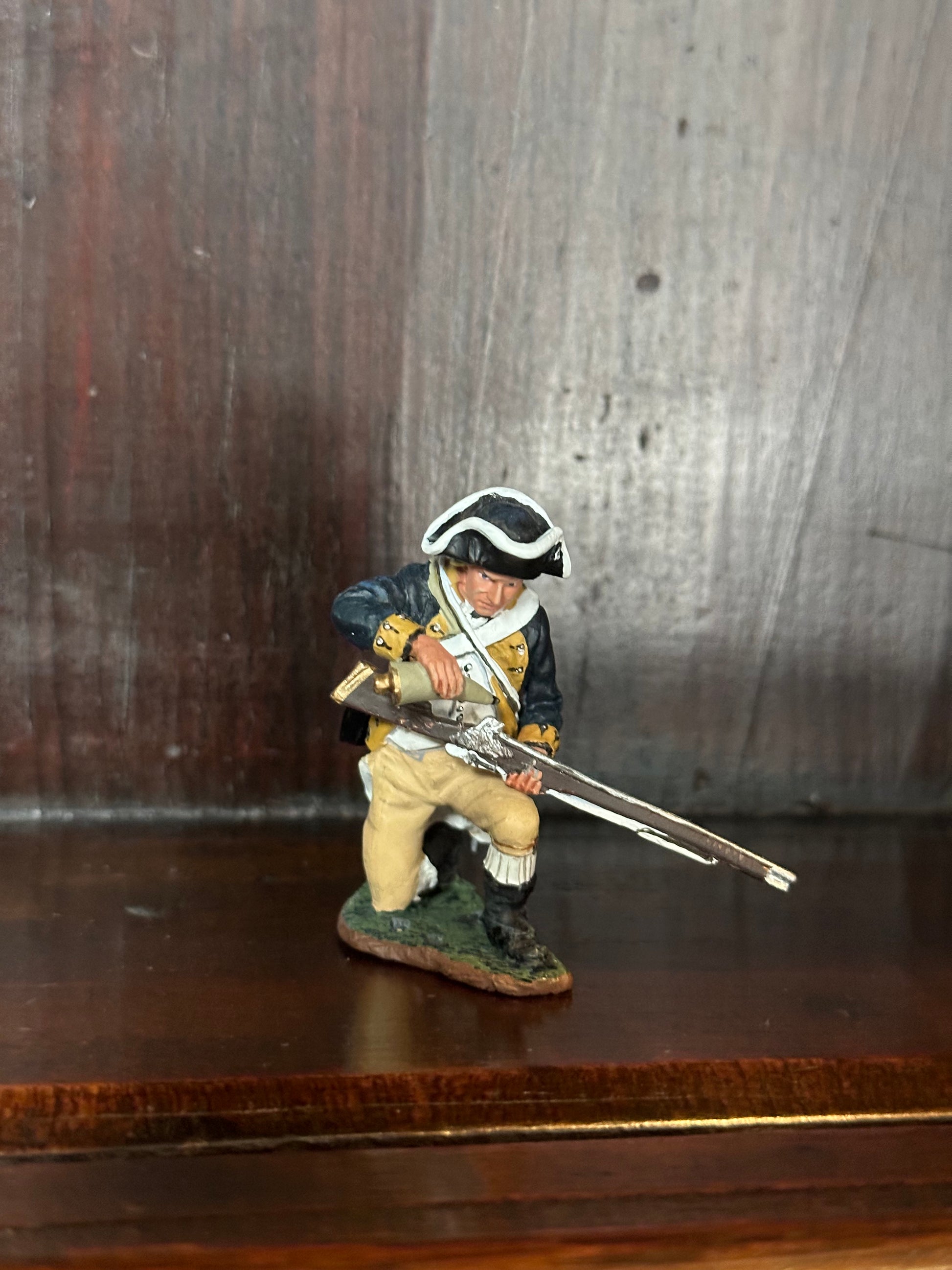 Collectible toy soldier army men Kneeling Loading Rifle. On book shelf.