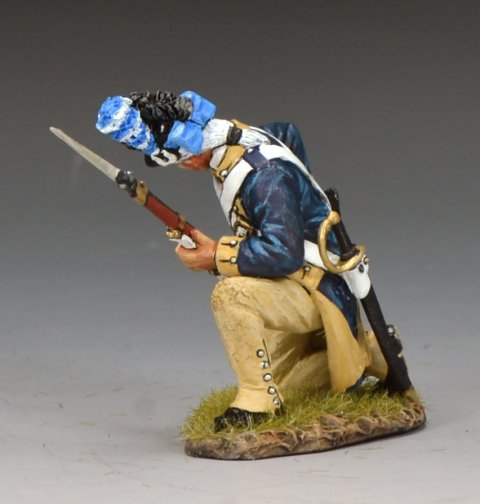 Model figure of a soldier in historical military attire with a rifle and blue headgear on a gray background.